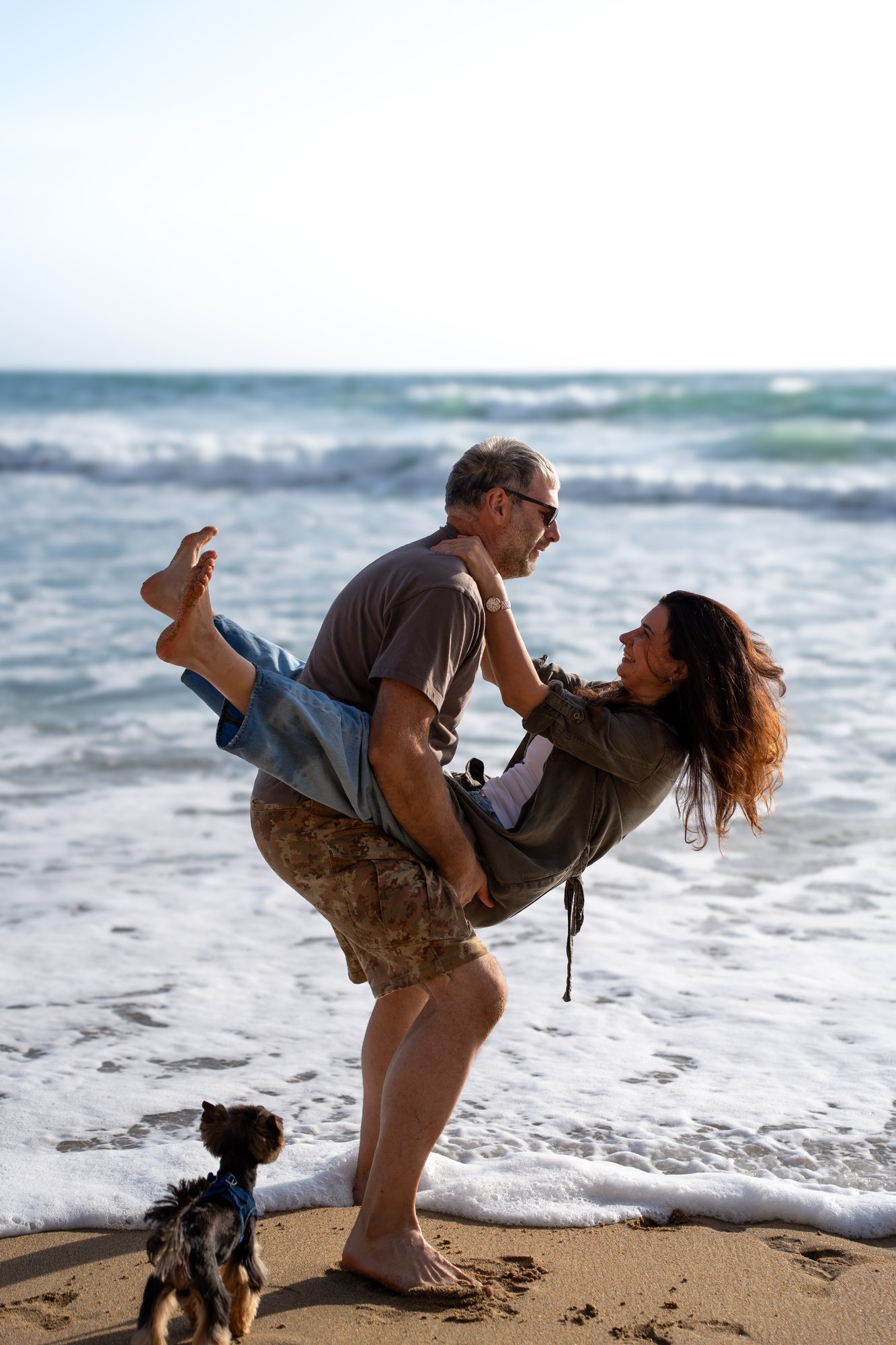A playful kiss and lift in the surf