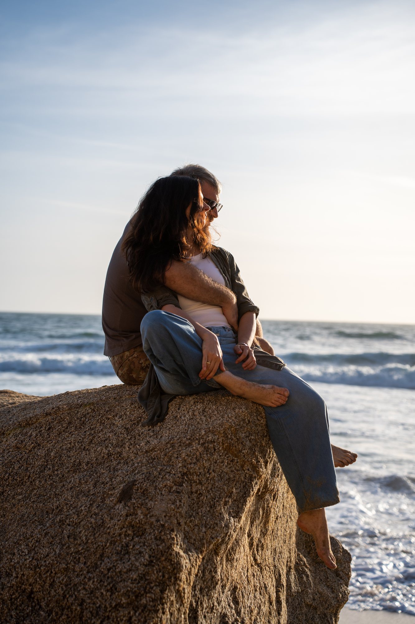 The woman sitting on a rock above the beach