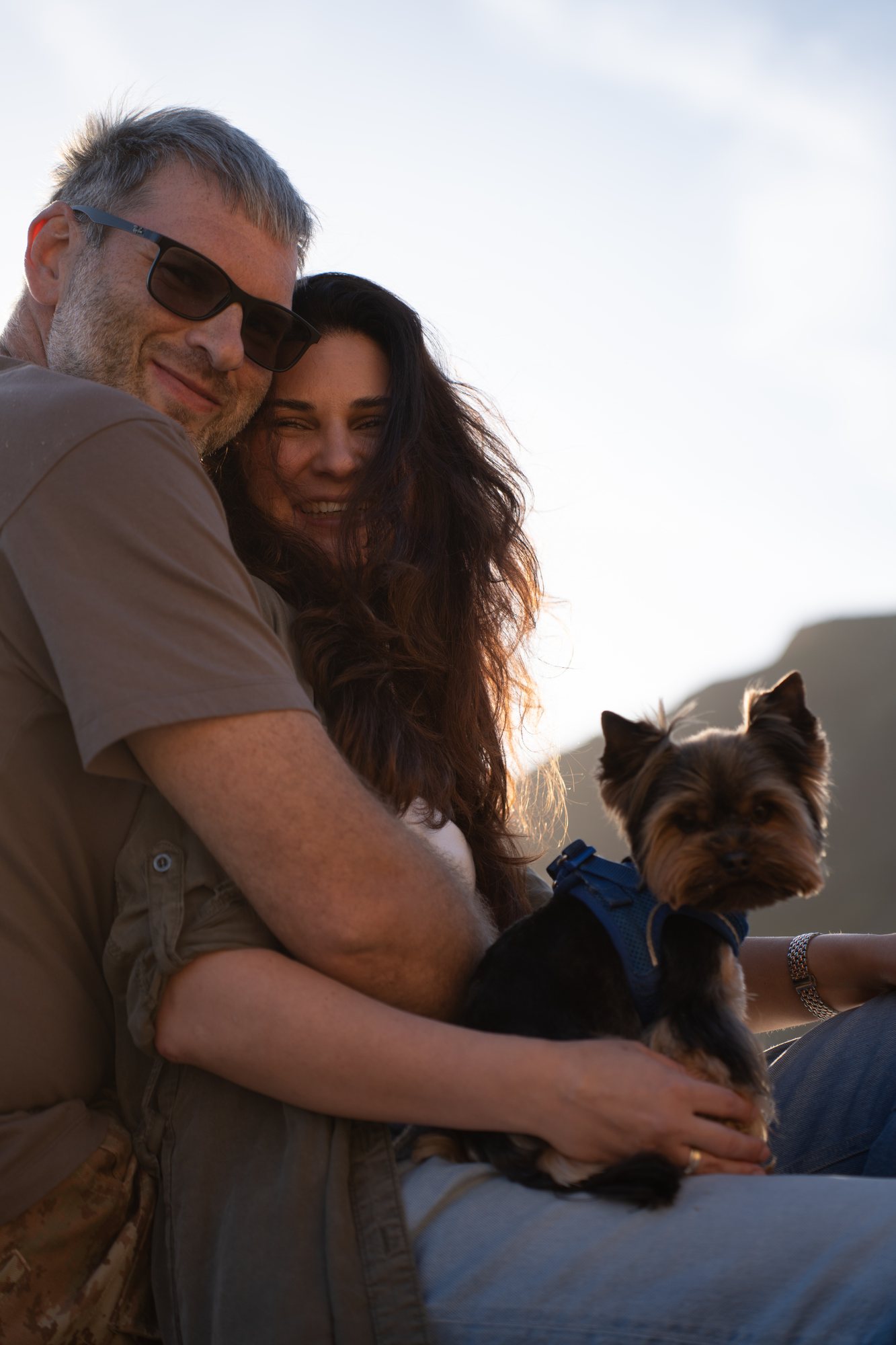 A warm embrace with their dog between them