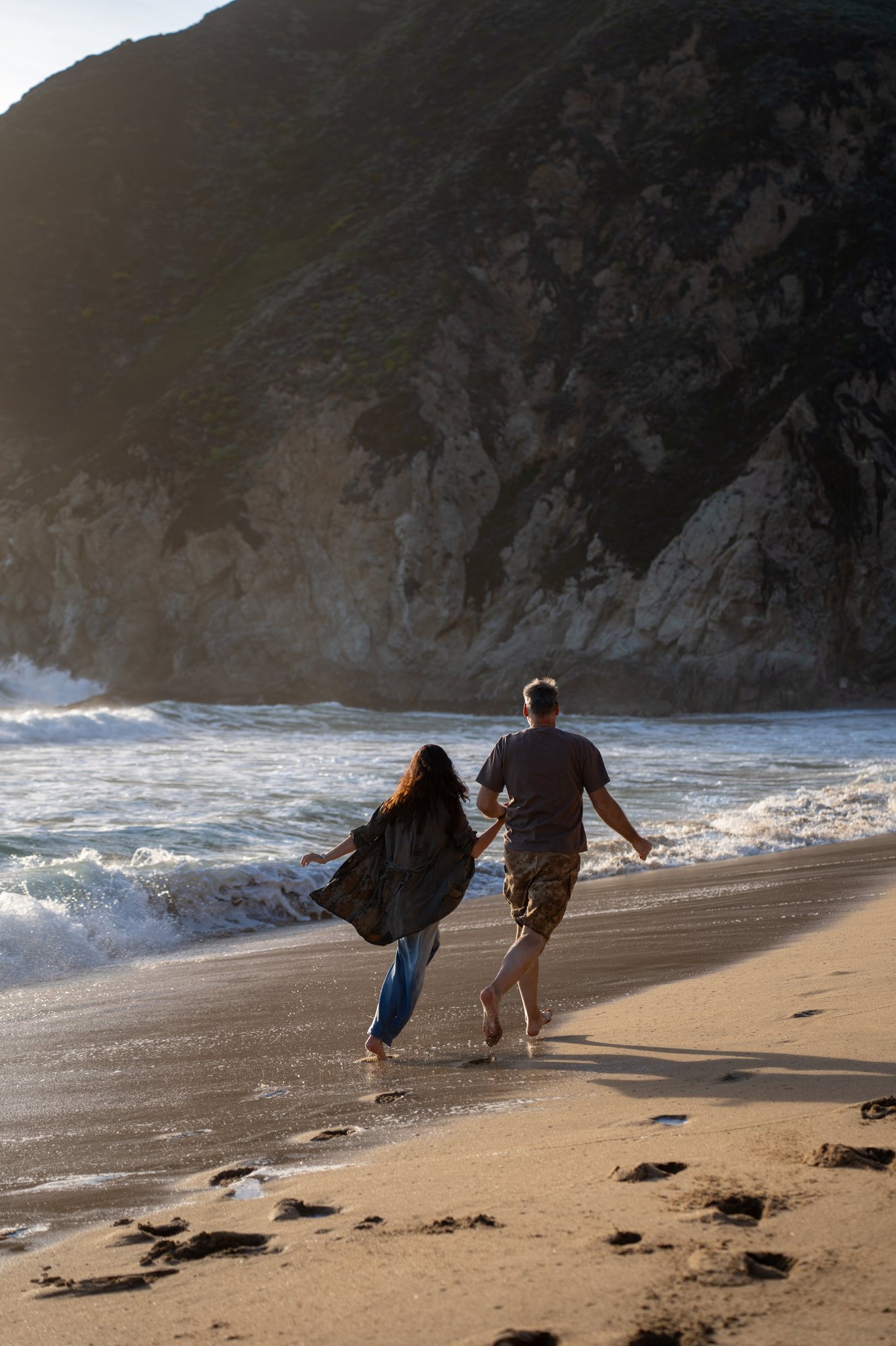 The couple running together along the beach