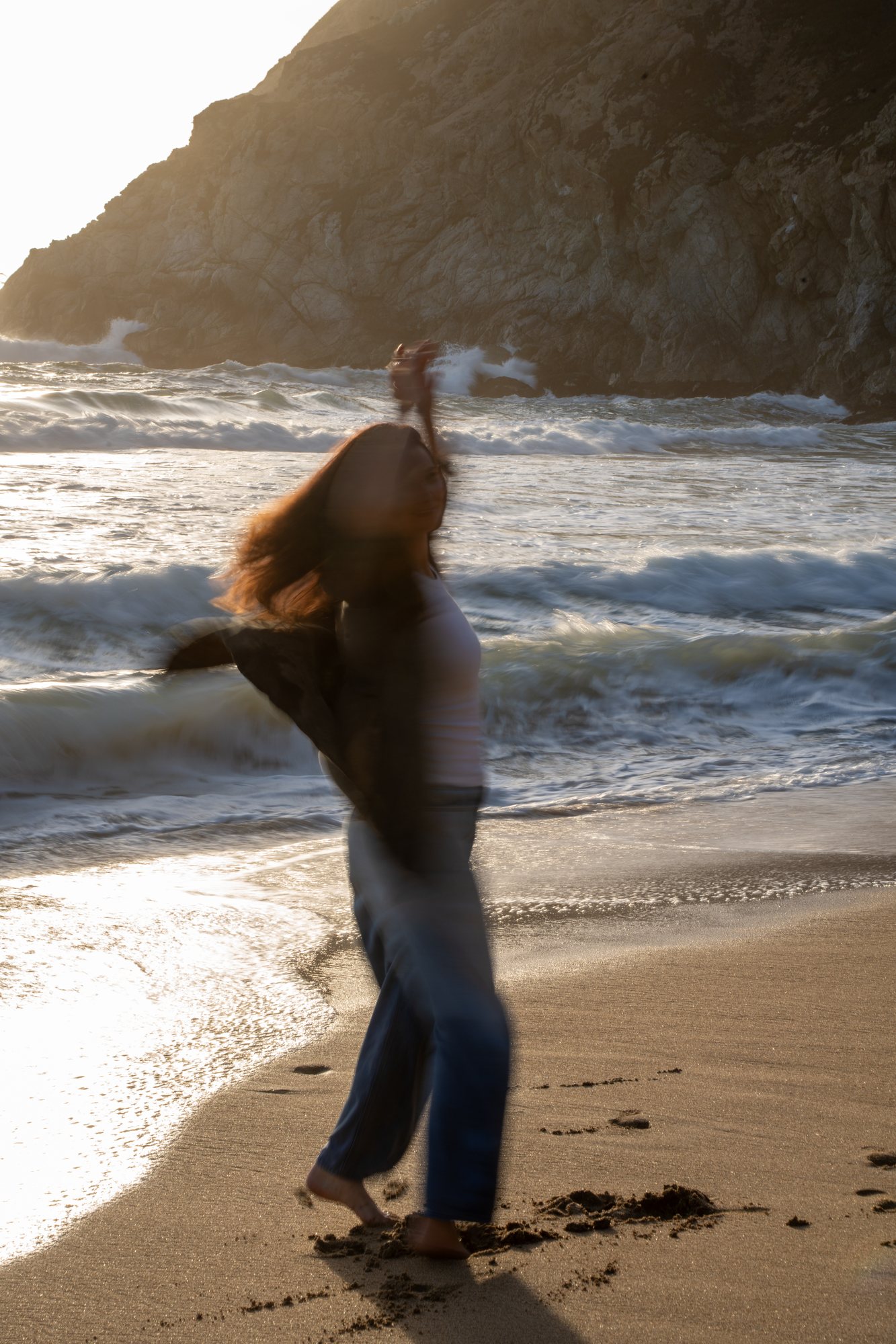 The woman moving in the sea breeze on the beach