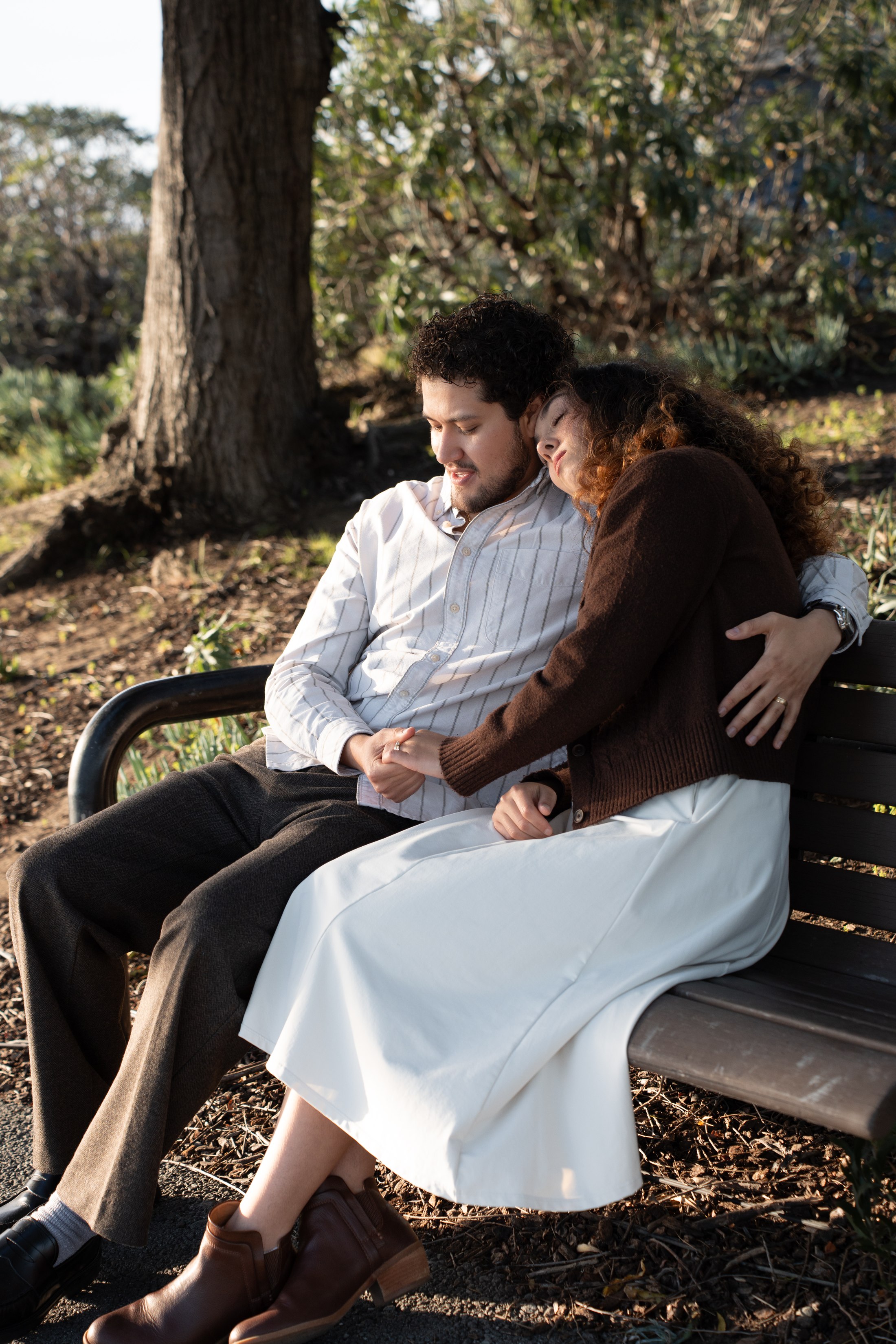 The couple leaning into each other on the bench