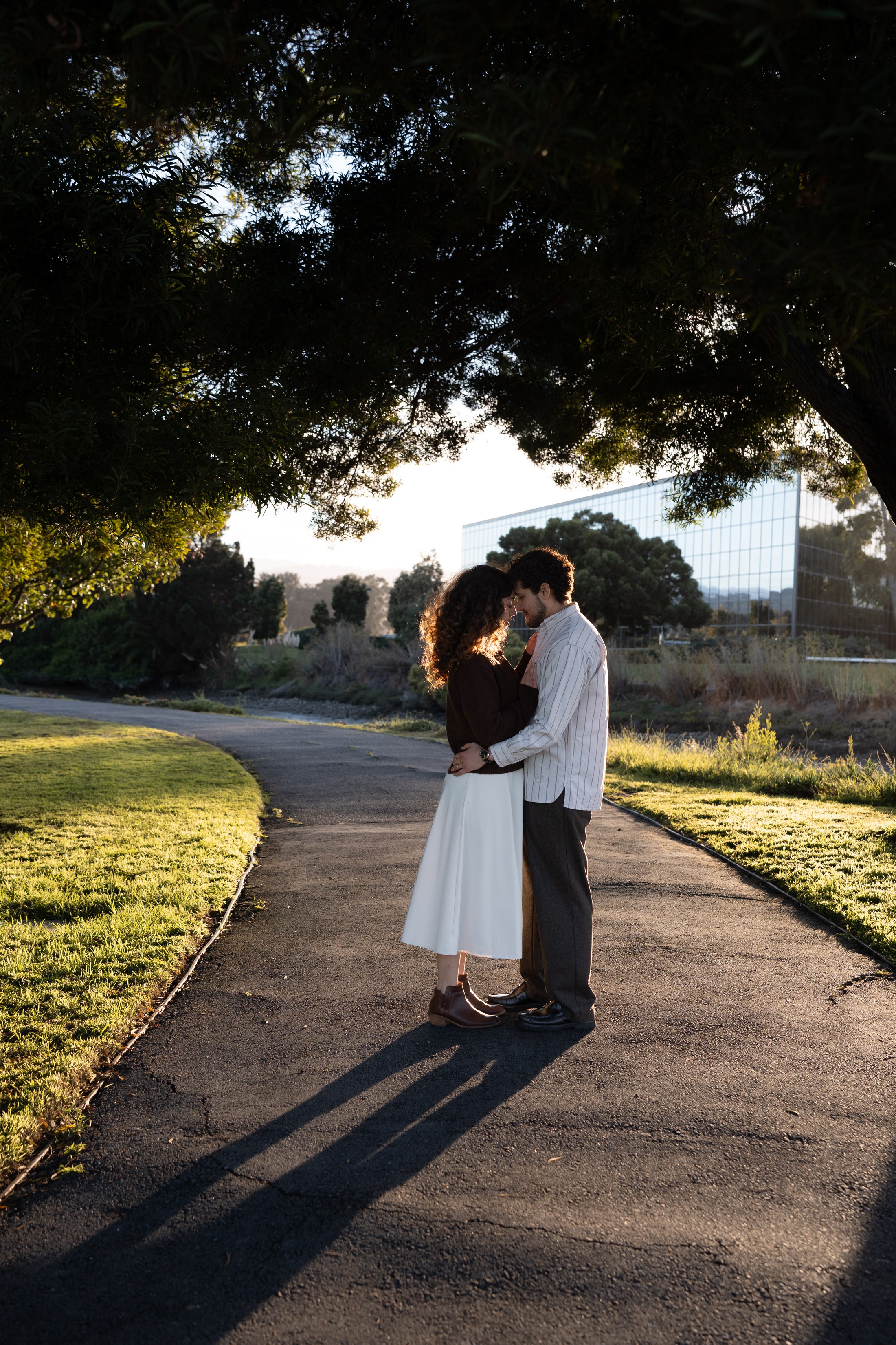 The couple walking along a path with long evening shadows