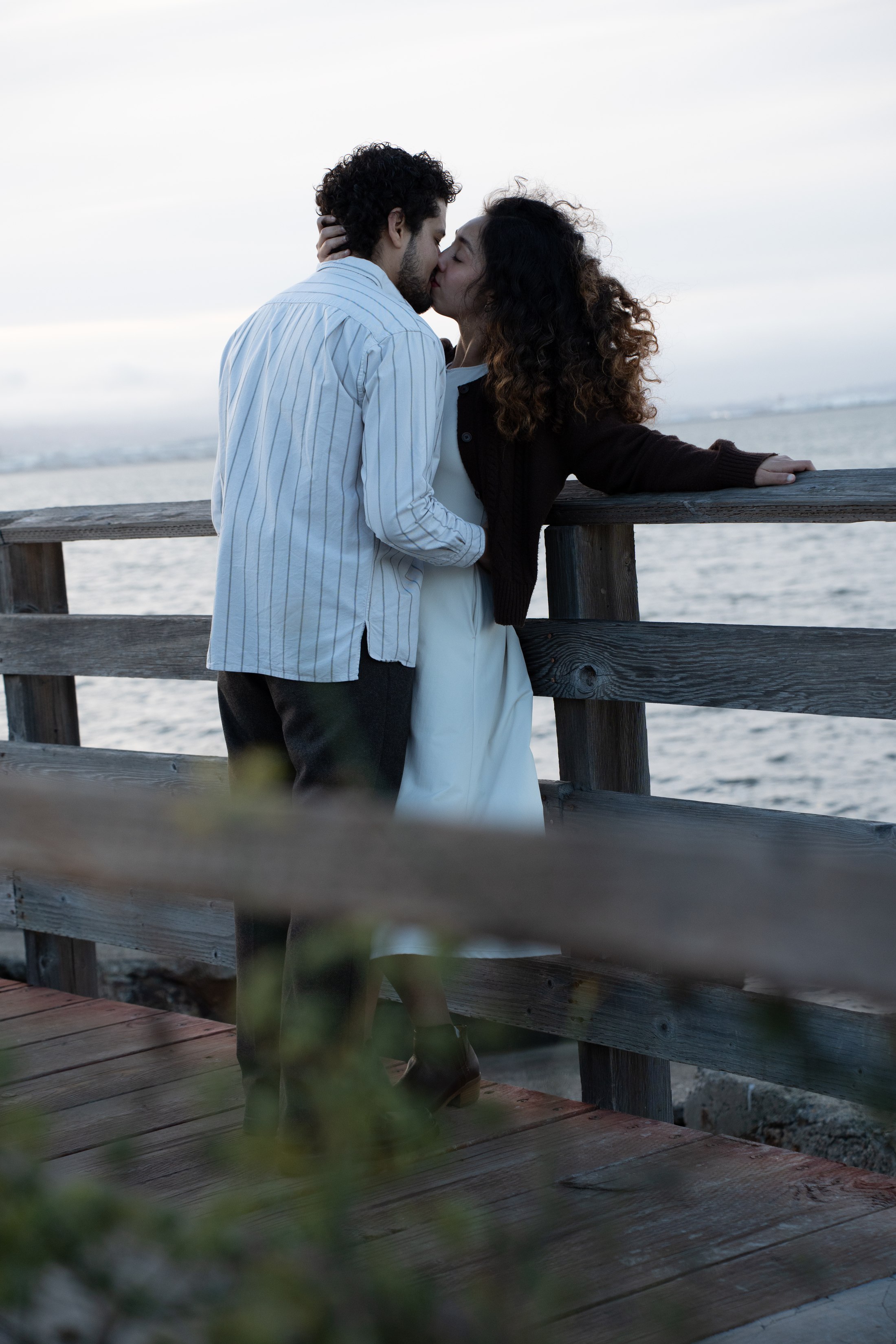 A view from behind as the couple rests by the water