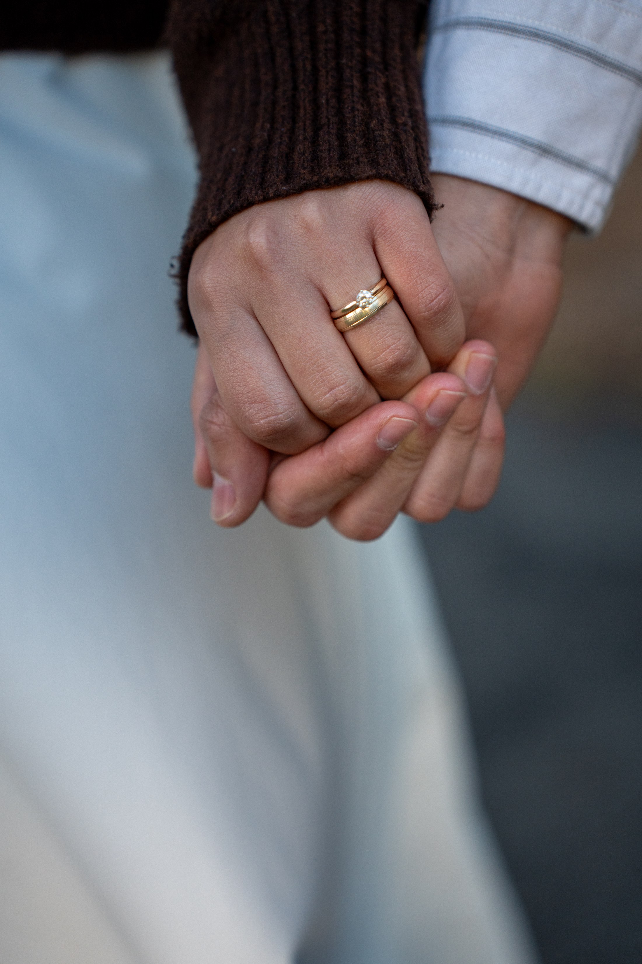 Their hands clasped together, rings visible