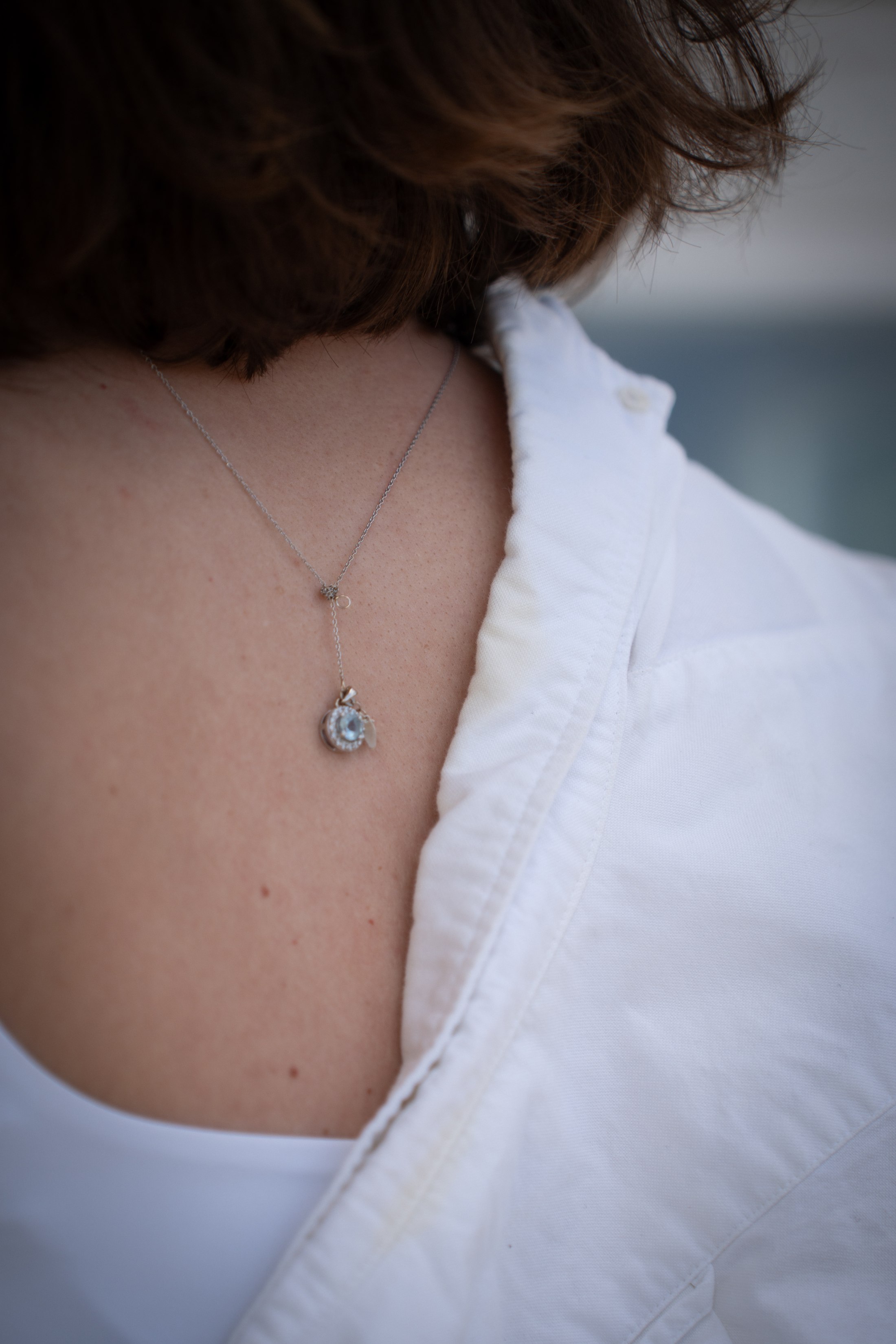 A small detail of the necklace and baby bump