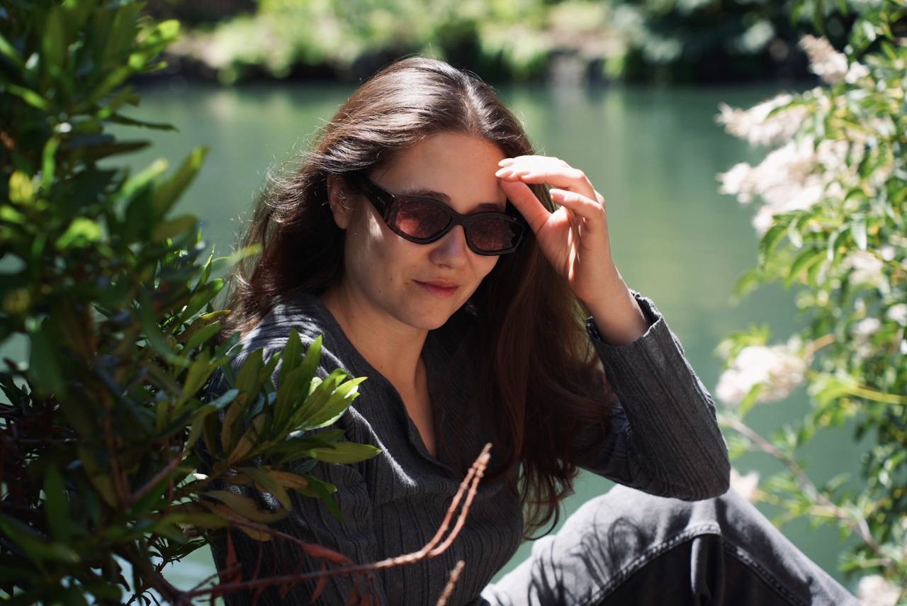 A woman in sunglasses sitting beside the water at the Palace of Fine Arts