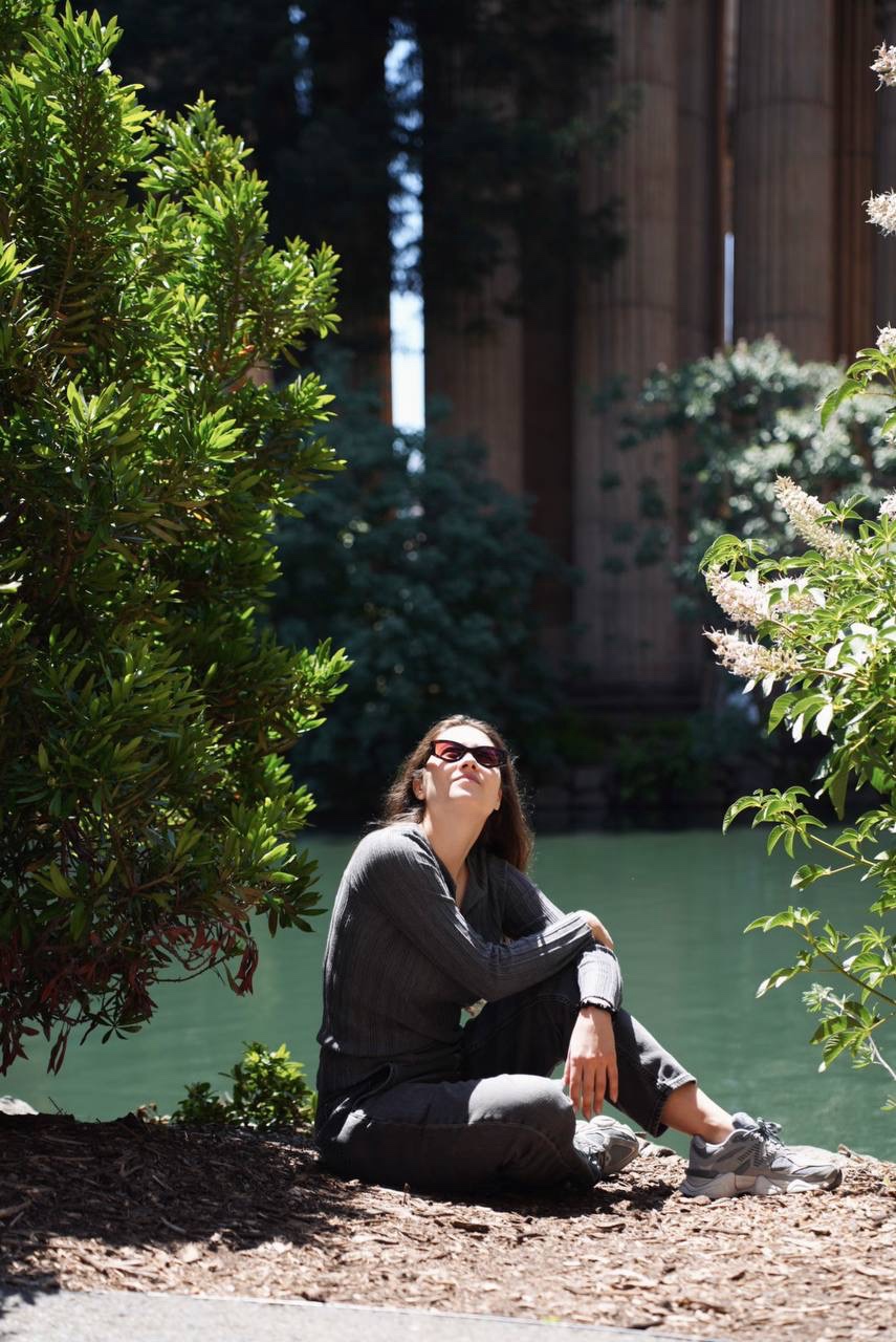 A woman sitting beneath the arches at the Palace of Fine Arts